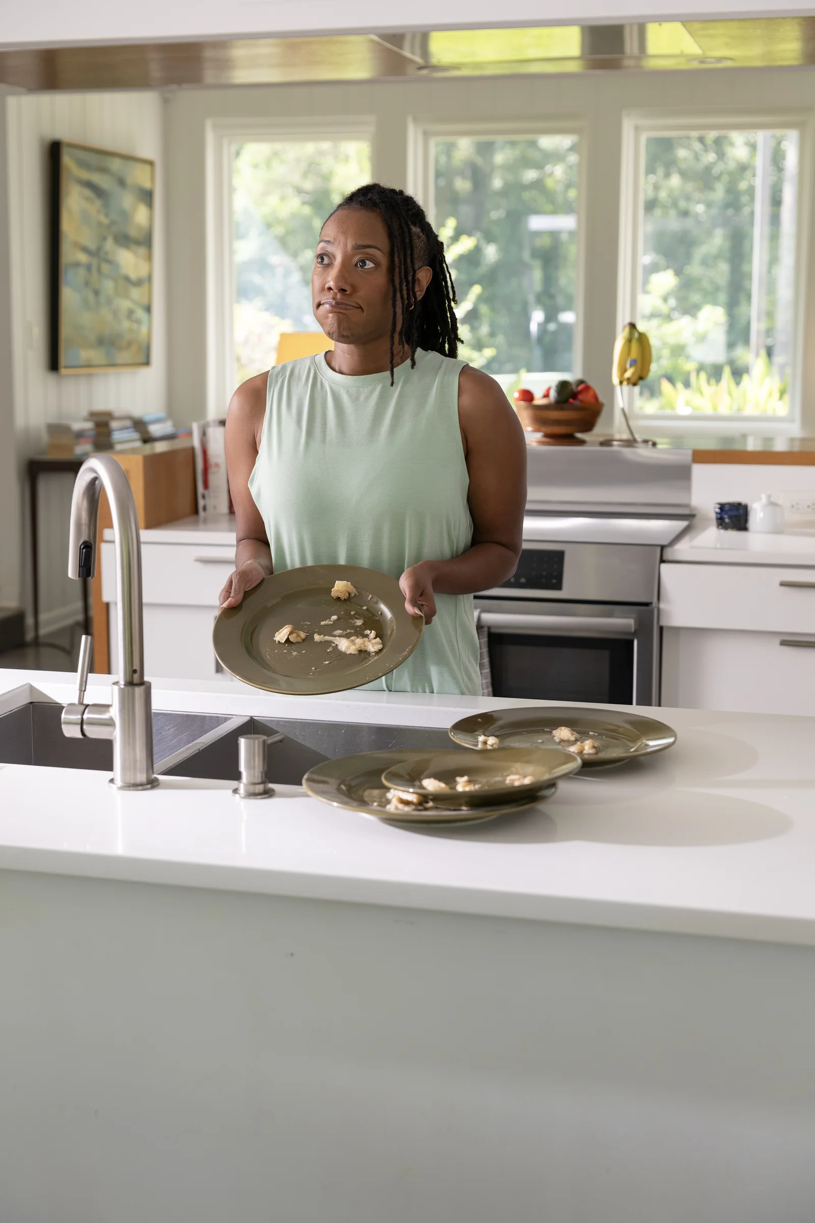 A neighbor holding dirty dishes in her kitchen